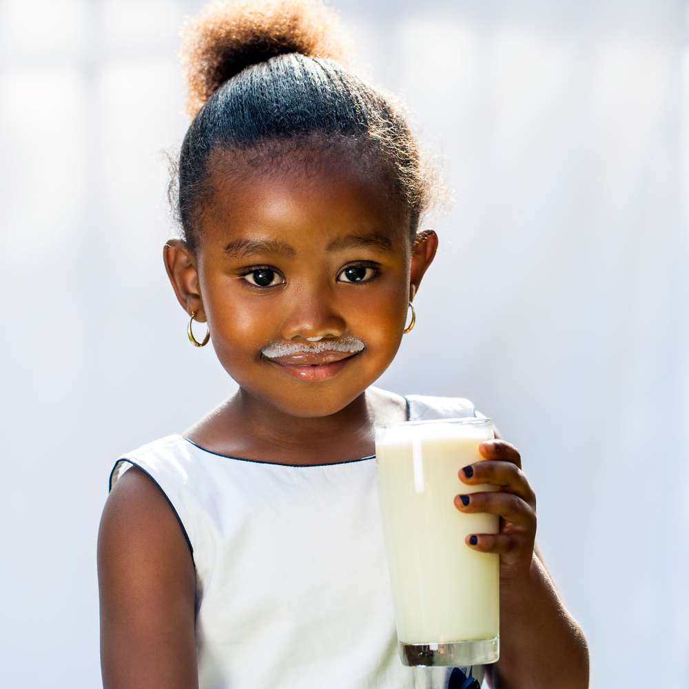 Photo showing little girl holding a glass of milk